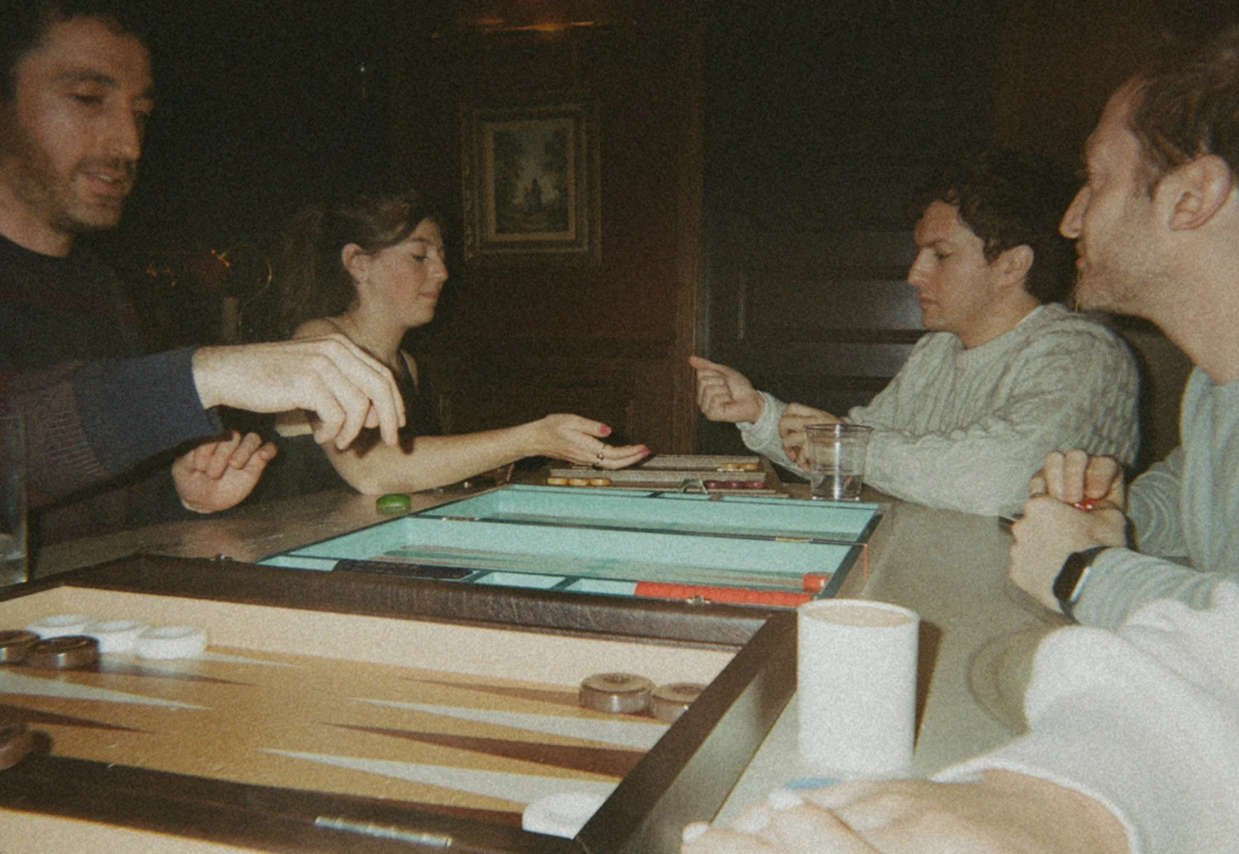 People with drinks and backgammon boards