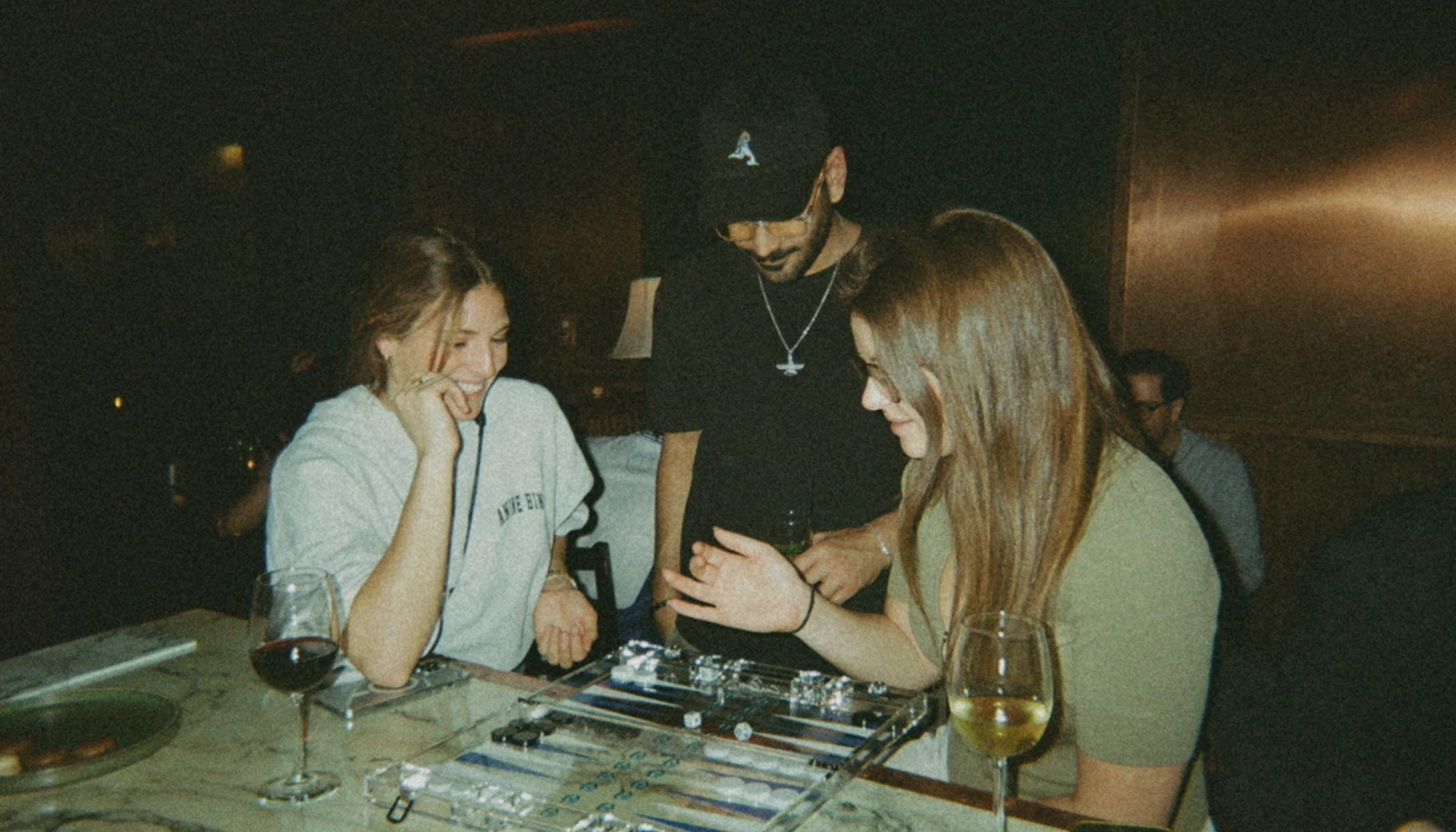 People with drinks and backgammon boards