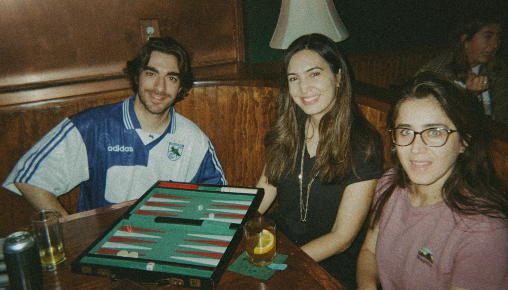 People with drinks and backgammon boards