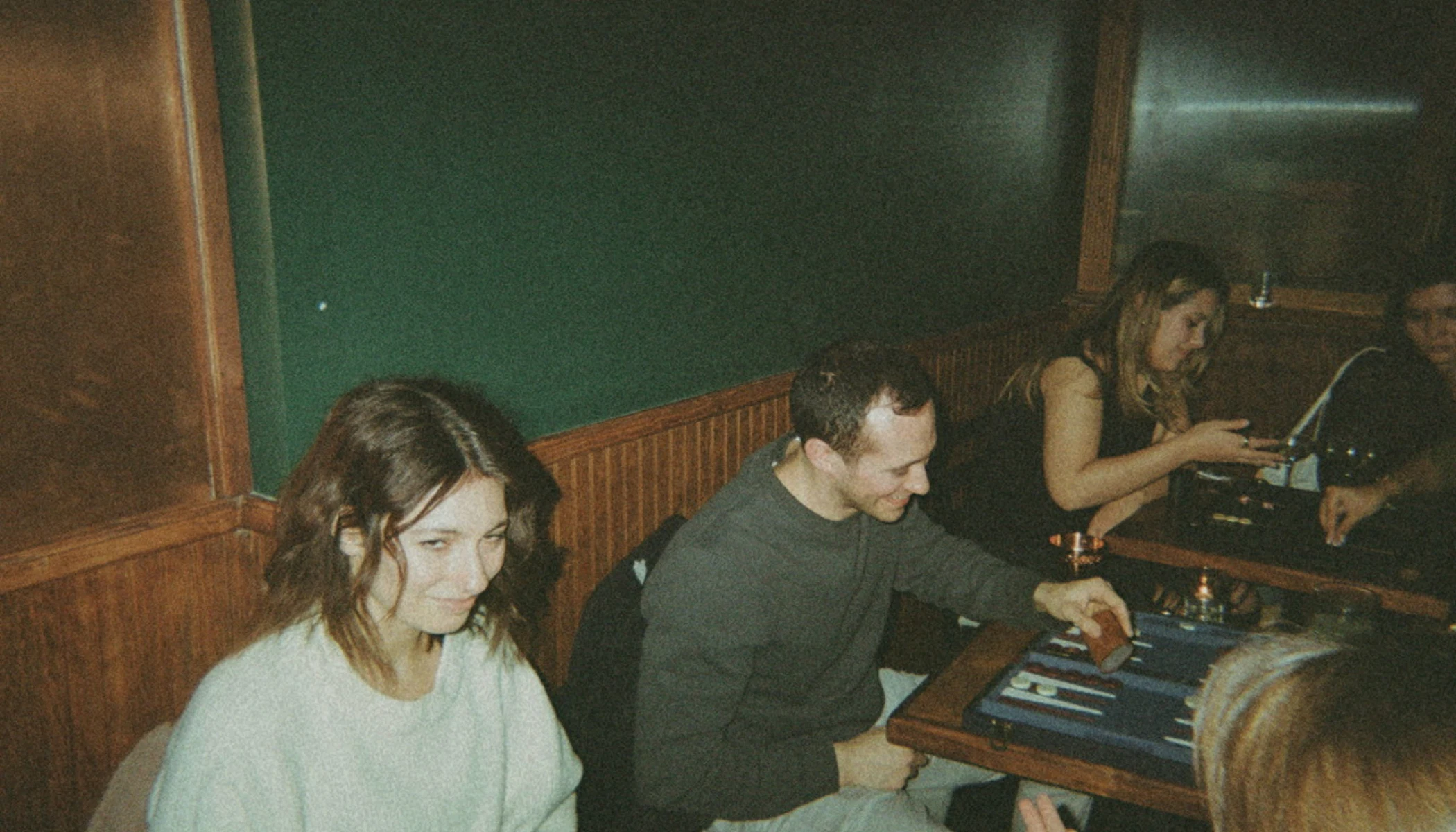 People with drinks and backgammon boards